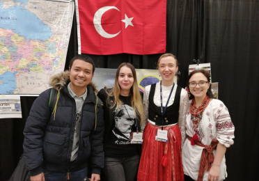Four students posing in front of a Turkish flag
